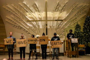 Performers from the zAmya Theater Project holding signs during their performance. 