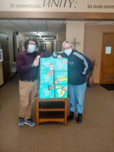 Charlie and Martha standing next to donated diapers. ing 